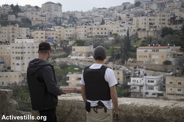 Private security guards stand atop a home taken over by Israeli settlers in the East Jerusalem neighborhood of Silwan, February 21, 2016. (Oren Ziv/Activestills.org)