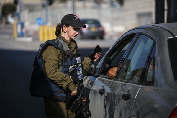 An Israeli military police officer checks IDs at the checkpoint at the entrance to Shuafat Refugee Camp in East Jerusalem, December 22, 2015. (Hadas Parush/Flash90)