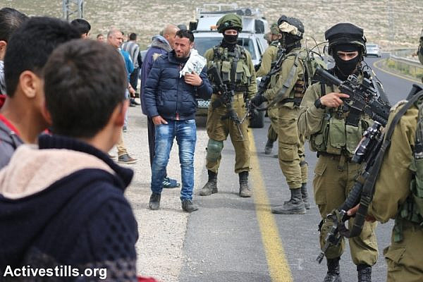 Palestinians take part in a protest against the Israeli military closure of the main entrance to Qalqas, near Hebron, which was imposed during the Second Intifada, West Bank, March 17, 2017. (Ahmad al-Bazz/Activestills.org)