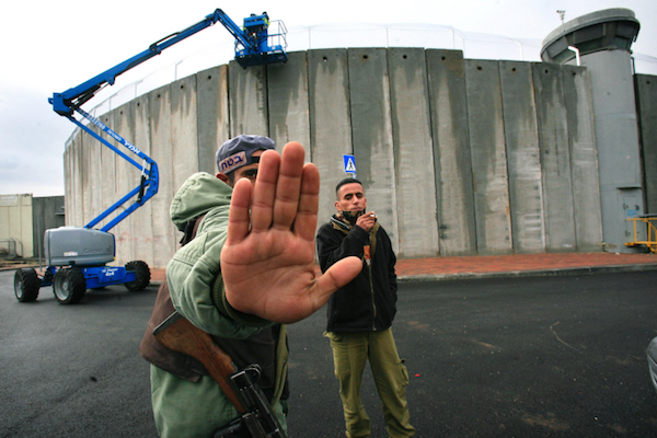 An Israeli soldier tries to prevent a photograph being taken of construction on the separation wall, Bethlehem, January 7, 2006. (Nati Shohat/Flash90)