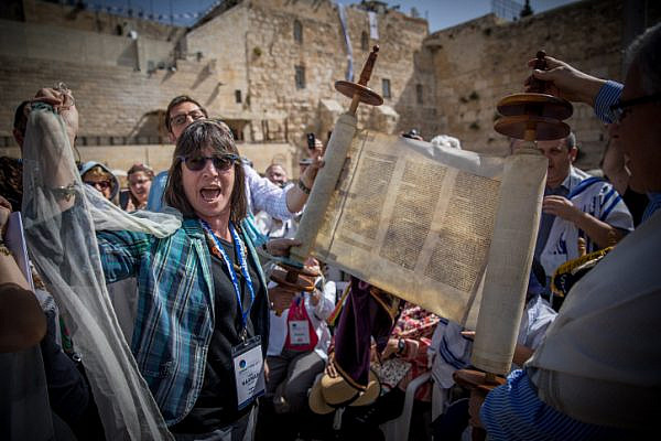 Members of the Reform and Conservative Jewish movements hold torah scrolls during a mixed men and women prayer at the public square in front of the Western Wall, in Jerusalem's Old City, on May 18, 2017. (Yonatan Sindel/Flash90)