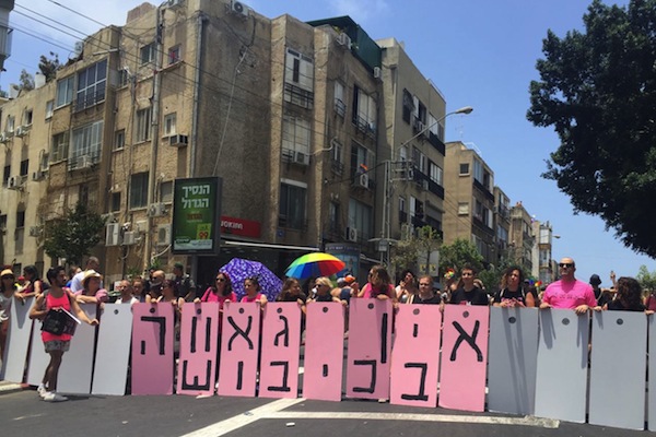 Queer anti-occupation activists block the Tel Aviv Pride Parade with signs reading: 'There's no pride in occupation', Tel Aviv, June 9, 2017. (Yael Marom)