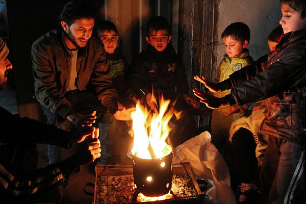 Palestinians warm themselves around a fire in Rafah in the southern Gaza Strip, on January 15, 2014, (Abed Rahim Khatib/Flash90)
