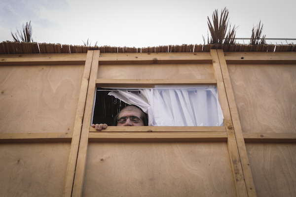 Illustrative photo of a Jewish Israeli man inside a sukkah, a temporary structure, during the Jewish holiday of Sukkot. (Flash90)