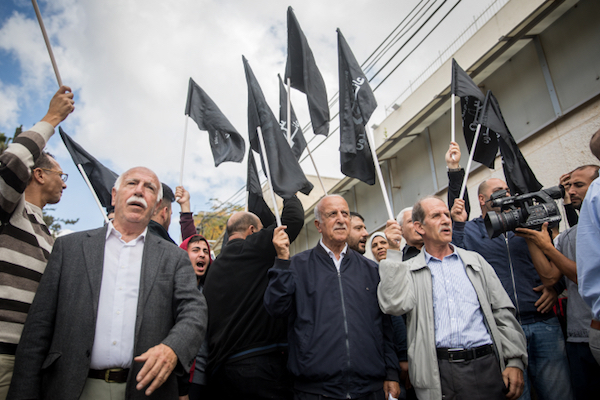 Palestinian men carry black flags at a protest marking 100 years since the Balfour Declaration outside the British Consulate in East Jerusalem, November 2, 2017. (Yonatan Sindel/Flash90)