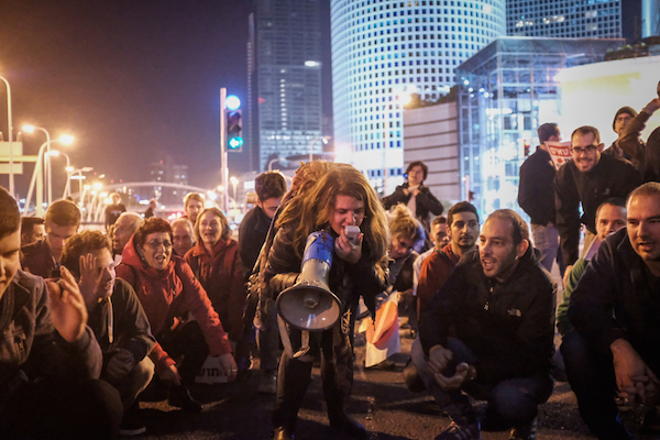 Israelis block a road during a protest against the corruption of the government in Tel Aviv on December 9, 2017. (Tomer Neuberg/Flash90)