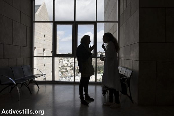 Dareen Tatour speaks with her attorney, Gaby Lasky, outside the Haifa courtroom where her trial was taking place. (Oren Ziv/Activestills.org)