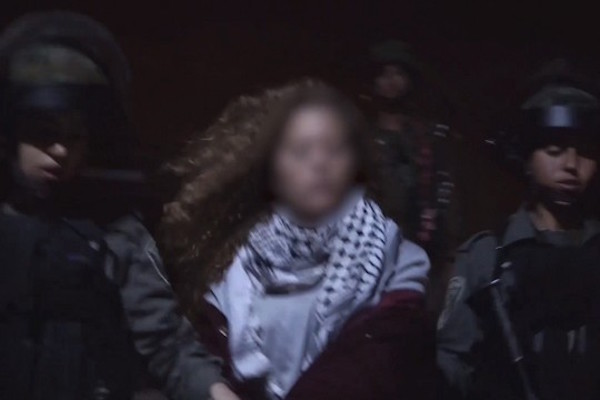 Border Police officers take Ahed Tamimi from her home in Nabi Saleh for interrogation, after she was filmed slapping and kicking IDF soldiers. (YouTube screenshot)