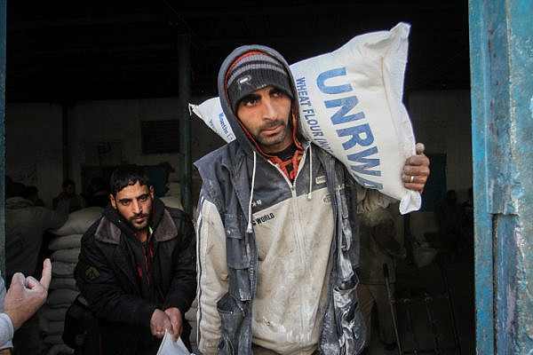 Palestinians in the southern Gaza city of Rafah receive monthly food rations from an UNRWA distribution center, January 23, 2017. (Abed Rahim Khatib/ Flash90)