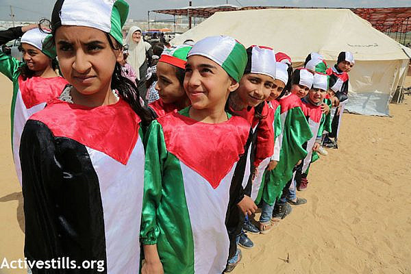 Palestinian children dressed in the colors of the Palestinian flag, at the protest encampment in Gaza east of Shujaiya. (Mohammed Zaanoun / Activestills.org)