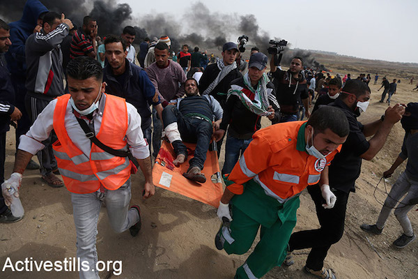 Palestinian medics evacuate a protester injured during the Great Return March in Gaza. April 20, 2018. (Mohammed Zaanoun / Activestills.)