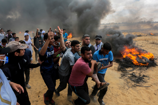 Protesters carry away someone who was shot by an Israeli sniper along the Gaza border, May 14, 2018. (Abed Rahim Khatib/Flash90)