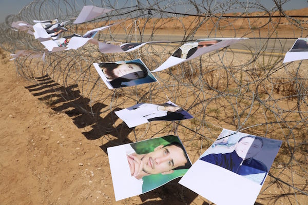 Pictures of slain Palestinian demonstrators hang on barbed wire near the Gaza-Israel separation barrier. June 26, 2018. (Oren Ziv / Activestills.org)