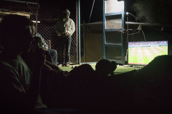Villagers and activists watch a World Cup match together in Khan al-Ahmar's schoolyard, July 2, 2018. (Oren Ziv)
