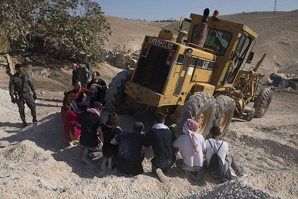 Palestinian, Israeli, and foreign activists attempt to block Israeli equipment brought to prepare for the demolition of Khan al-Ahmar, July 5, 2018. (Oren Ziv/Activestills.org)