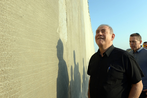 Prime Minister Benjamin Netanyahu visits the separation wall near Tarqumiya in the West Bank, July 20, 2016. (Haim Zach/GPO)