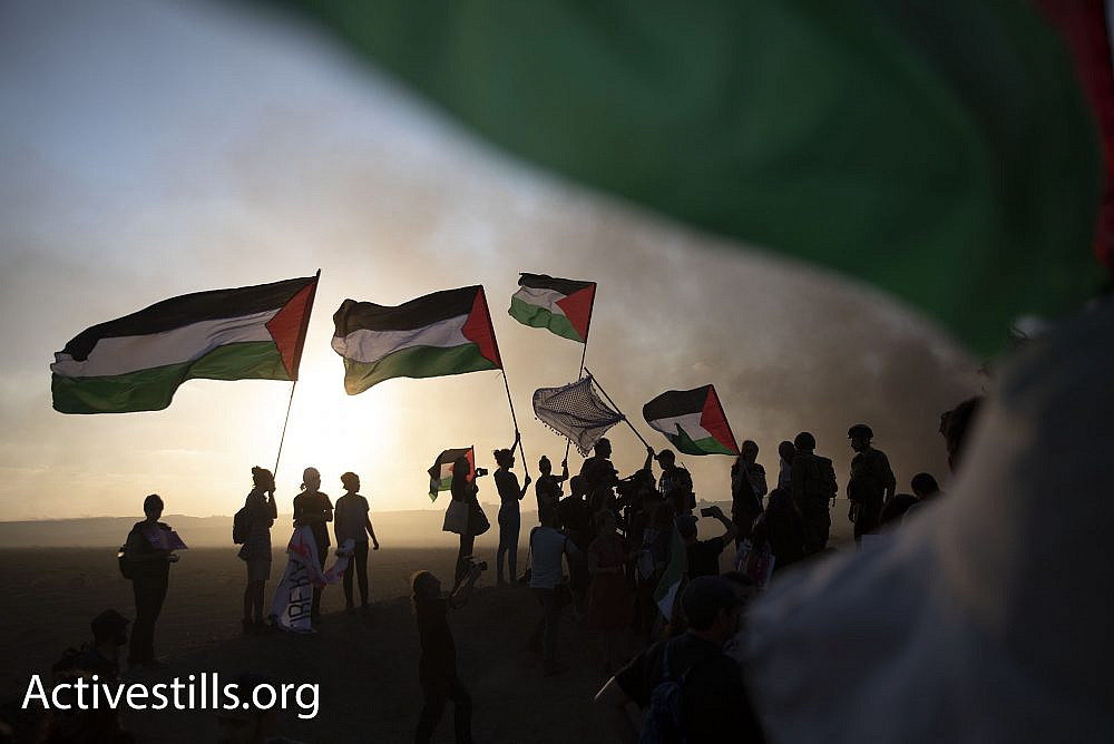 Dozens of Israeli and Palestinian activists protested on the Israeli side of the Gaza fence in solidarity with the Great Return March. Palestinian demonstrators responded with cheers of joy at the sight of the Palestinian flags. (Oren Ziv/Activestills.org)