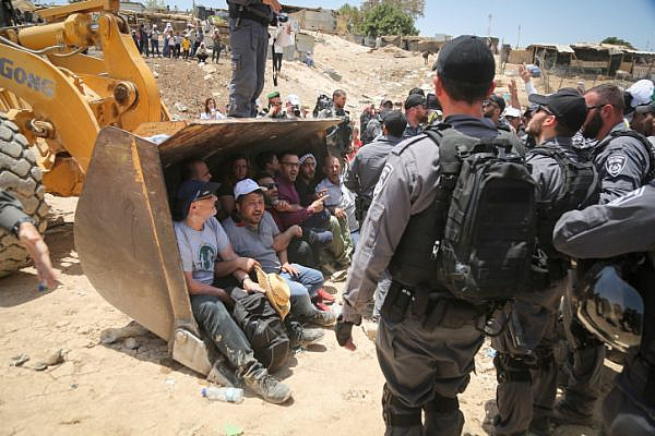 Israeli policemen scuffle with Palestinian demonstrators in the Bedouin village of Khan al-Ahmar, east of Jerusalem, on July 4, 2018. (Flash90)