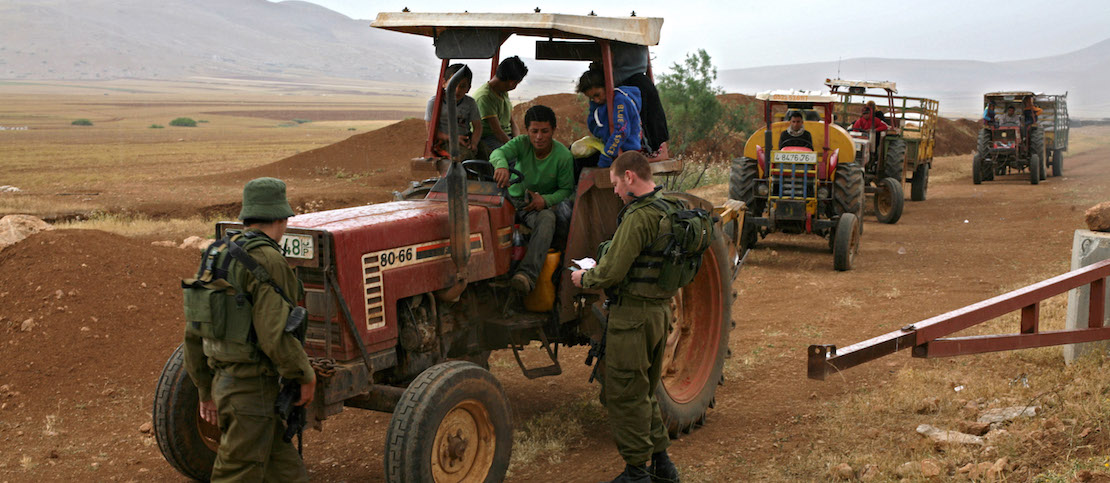 Israeli soldiers look through IDs belonging to a group of Palestinians, Jordan Valley, West Bank, April 28, 2011. (Activestills.org)