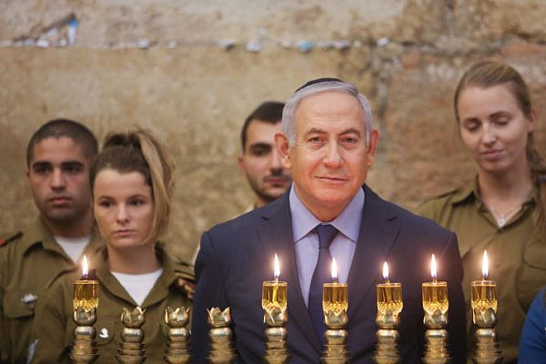 Israeli Prime Minister Benjamin Netanyahu lights the 'Hanukkia' on the First night of the Jewish holiday of Hanukkah at the Western Wall in Jerusalem, December 06, 2018. (Marc Israel Sellem/GPO)