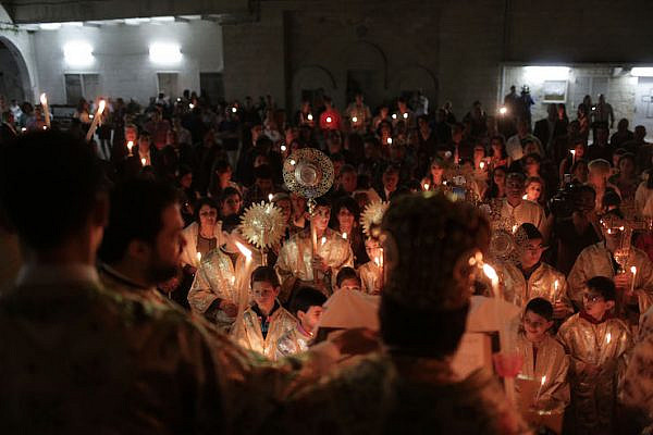 Palestinian Christians hold candles lit by the holy fire, which was delivered from the Church of the Holy Sepulcher in Jerusalem, at the Church of Saint Porphyrius in Gaza City, on April 20, 2014. (Wissam Nassar/Flash90)