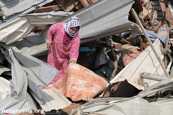 A Palestinian woman examines the damage caused to her house after Israeli forces demolished it, Al Hadidiya, Jordan Valley, West Bank, October 11, 2018. (Ahmad Al-Bazz/Activestills.org)