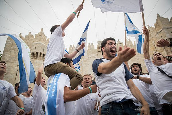 Thousands of Jewish wave the Israeli flags as they celebrate Jerusalem Day in Damascus Gate on their way to the Western Wall. Jerusalem Day celebrations, May 13, 2018. (Yonatan Sindel/Flash90)