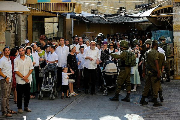Israeli security forces guard as Jews tour the Palestinian side of the old city market in the West Bank city of Hebron, June 15, 2019. (Wisam Hashlamoun/Flash90)