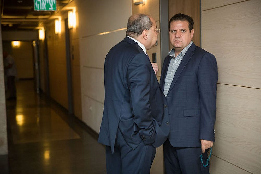 Leader of the Joint List Ayman Odeh (R) and party member Ahmad Tibi arrive for a meeting with party members at the Knesset on September 22, 2019. (Yonatan Sindel/Flash90)