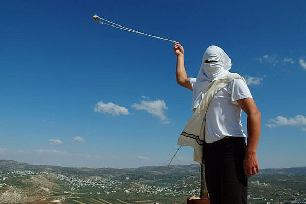 Illustrative photo of a masked Jewish settler with a slingshot in the West Bank settlement of Yitzhar, May 19, 2013. (Mendy Hechtman/Flash90)