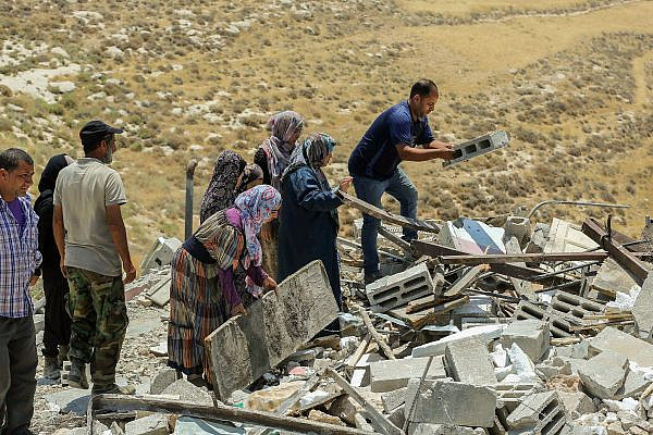 Palestinians sift through the rubble after Israeli forces demolished their home in the hamlet of Khalet al-Daba, in the occupied West Bank, June 17, 2019. (Wissam Hashlamon/Flash90)