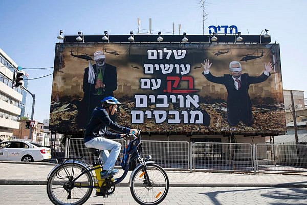 A billboard put up by the far-right Israel Victory Project in Tel Aviv shows blindfolded Palestinian leaders Ismail Haniyeh and Mahmoud Abbas. The caption reads: 'Peace is made with defeated enemies.' (Oren Ziv)