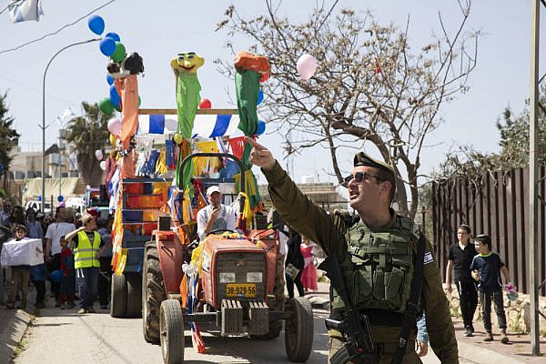 An Israeli soldier seen during the annual Purim parade in Hebron's city center, West Bank, March 10, 2020. (Oren Ziv)