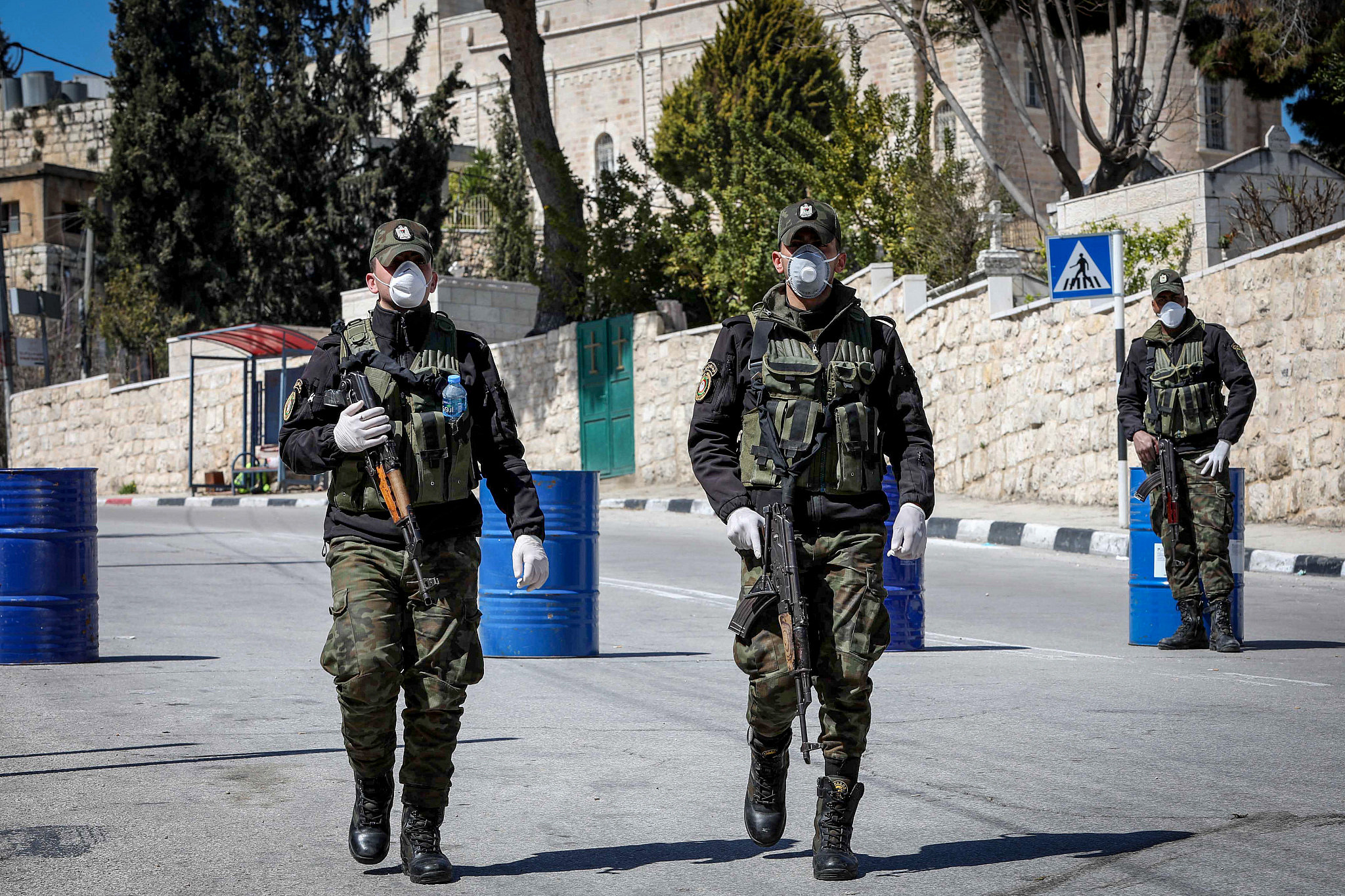 Palestinian security forces wearing face masks block the entrance to the West Bank city of Bethlehem, March 8, 2020. (Wisam Hashlamoun/Flash90)