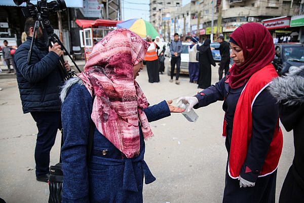 Palestinian health workers give passersby hand sanitizer in Gaza City as a precaution from COVID-19, March 15, 2020. (Ali Ahmed/Flash90)