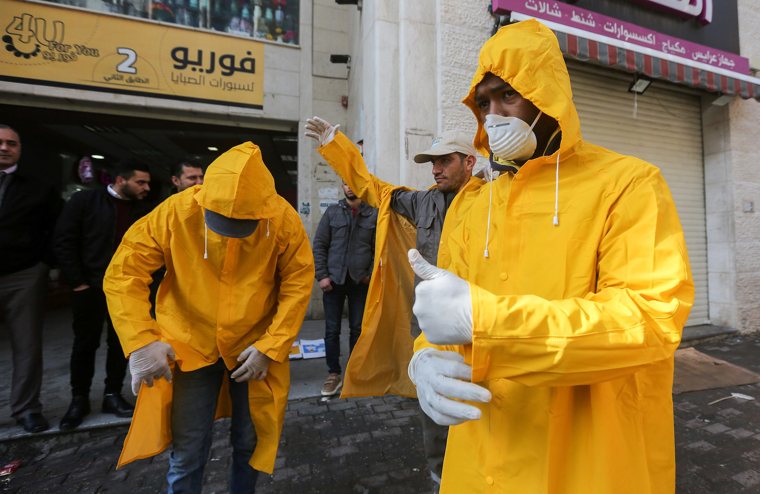 Workers disinfect a mall in the West Bank city of Hebron, March 15, 2020, as part of measures to prevent the spread of the coronavirus. (Wisam Hashlamoun/Flash90)