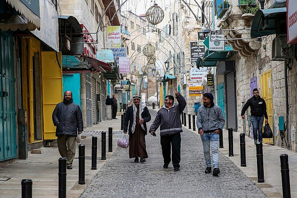 Palestinians walk on a street in the West Bank city of Bethlehem, March 19, 2020. (Wisam Hashlamoun/Flash90)