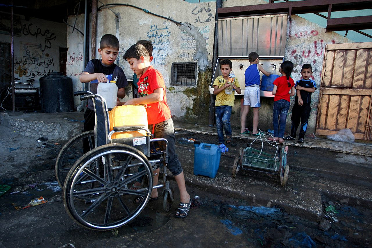 Palestinians fills jerrycans with drinking water from public taps during the Muslim holy month of Ramadan, in Rafah refugee camp in the southern Gaza Strip on June 11, 2017. (Abed Rahim Khatib/Flash90)