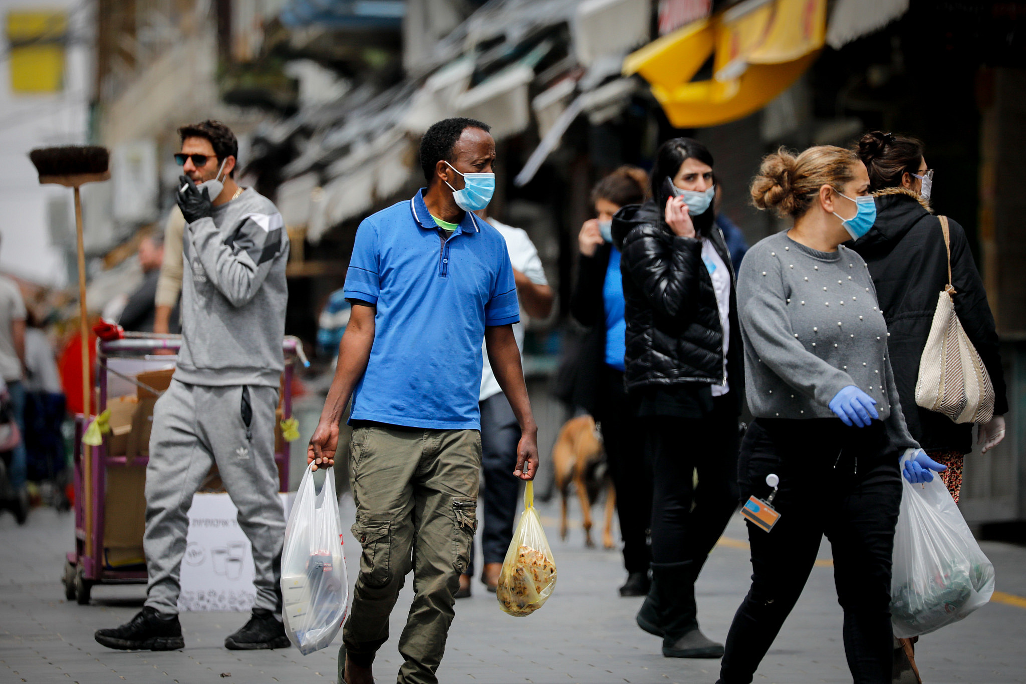 People wear protective face masks as they shop for food at the Mahane Yehuda market in Jerusalem on April 7, 2020. (Olivier Fitoussi/Flash90)