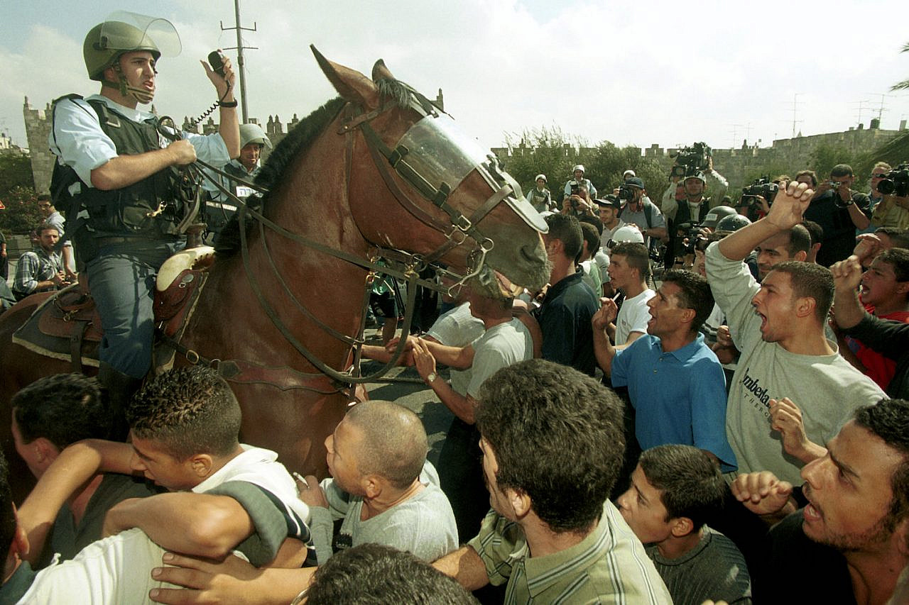 An Israeli police on horseback enters a crowd of Palestinians during clashes in the first days of the Second Intifada, October 20, 2000. (Flash90)