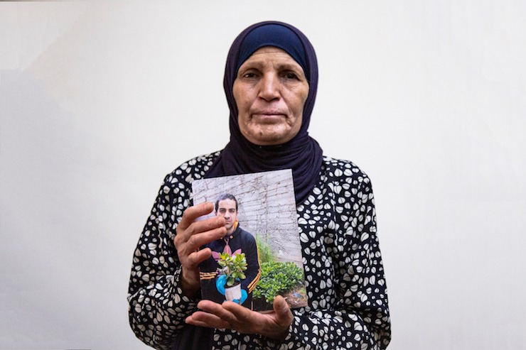 The mother of Iyad Hallak, the Palestinian man with autism who was killed by Border Police officers, holds up a photo of her son, Jerusalem, June 2, 2020. (Activestills.org)