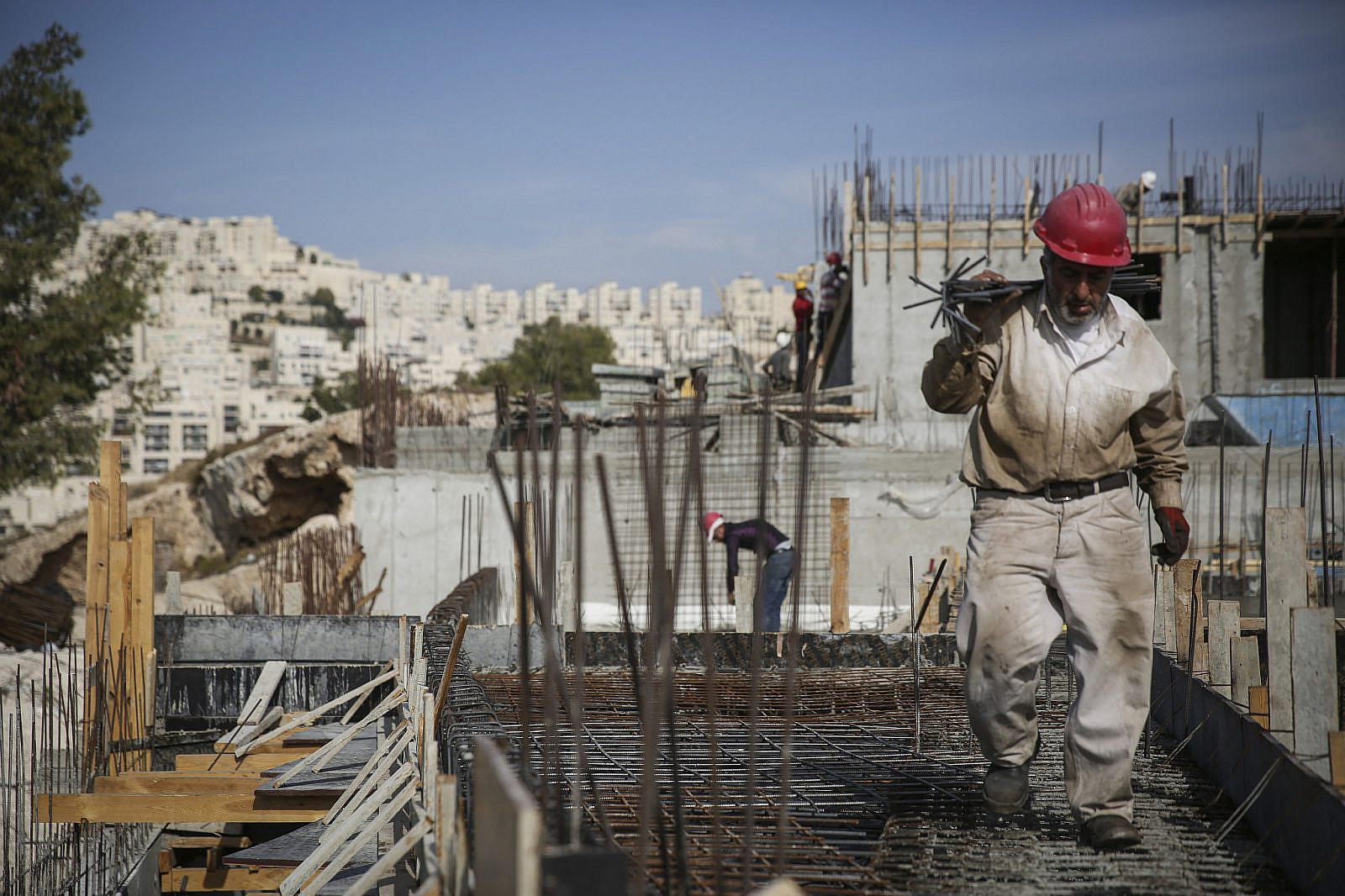 Palestinian workers during construction work on new apartment buildings in the Jewish neighborhood of Har Homa, East Jerusalem. October 28, 2014. (Hadas Parush/Flash90)