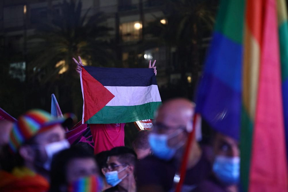 A left-wing activist holds up a Palestinian flag at Tel Aviv Pride, June 28, 2020. (Oren Ziv/Activestills)