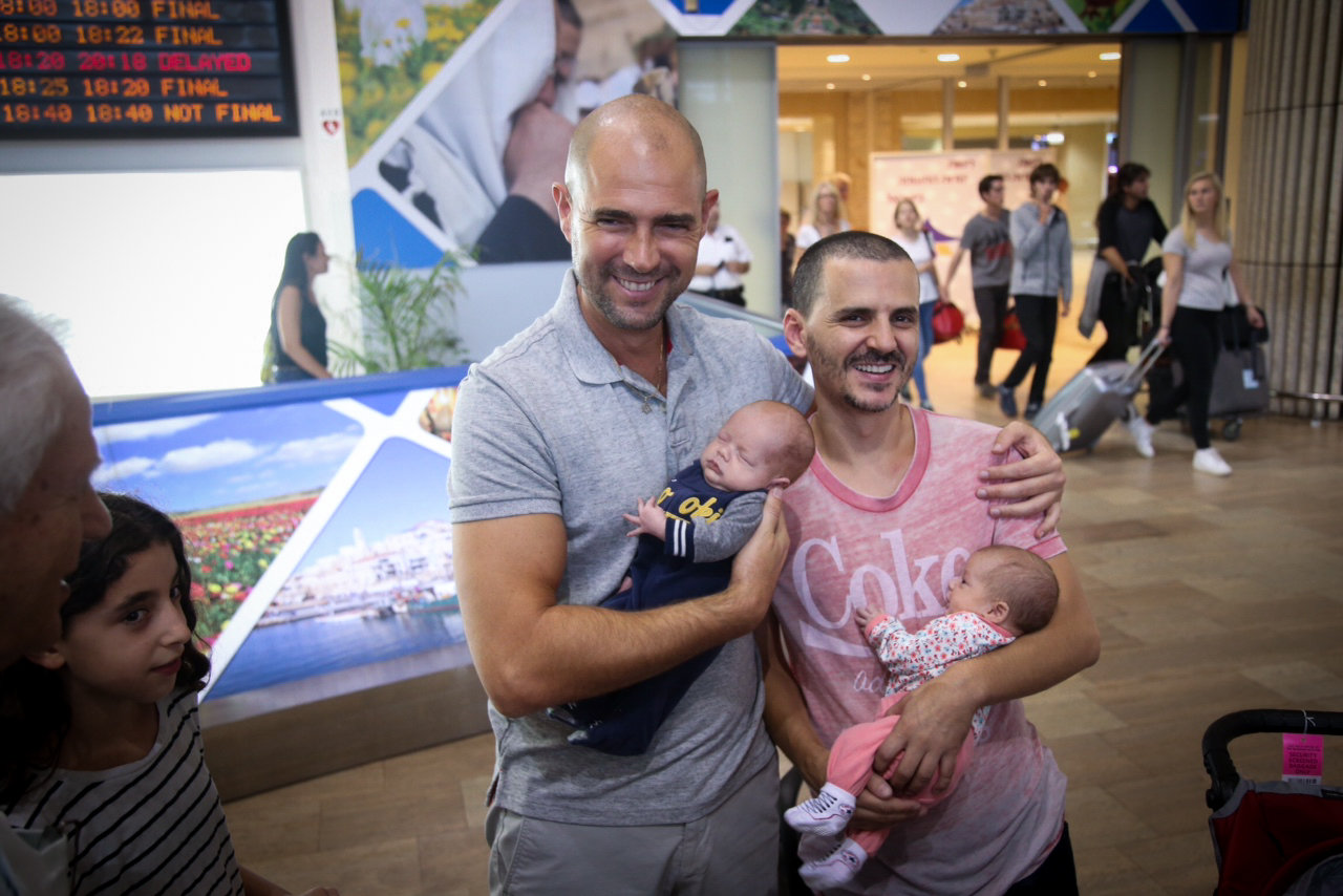 Likud MK Amir Ohana and his partner seen at Ben Gurion International Airport upon their return from the U.S. with their surrogate babies, September 26, 2015. (Flash90)