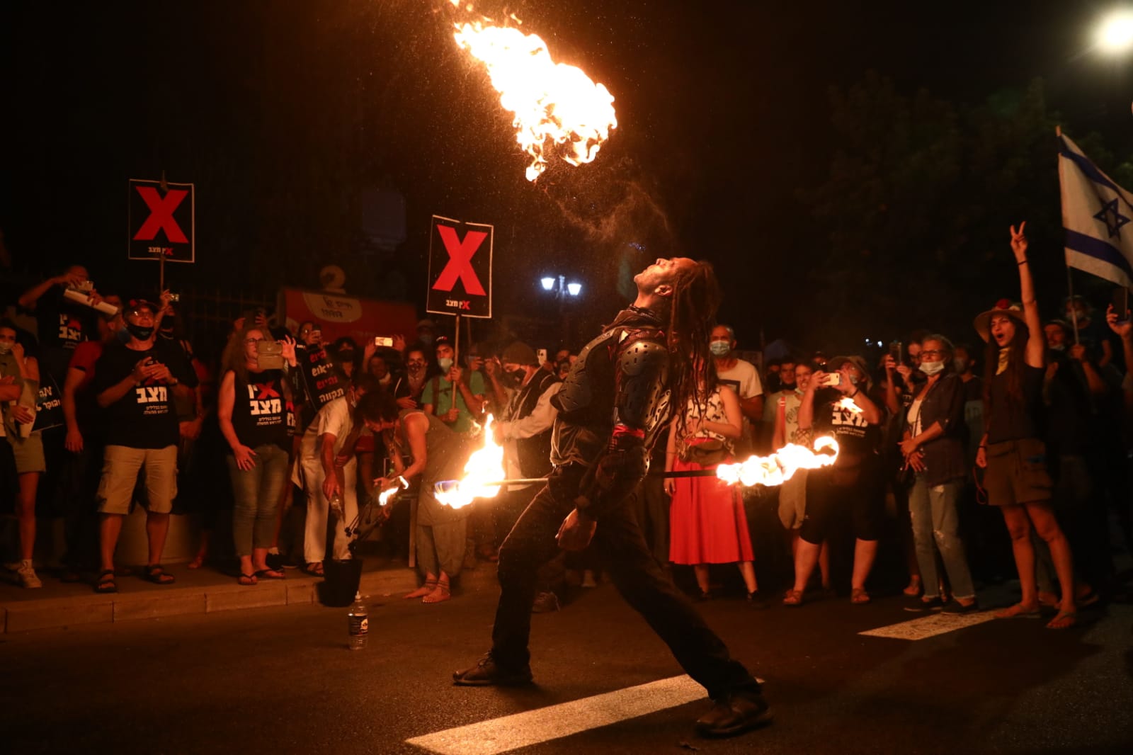 A fire eater performs for protesters during an Israeli demonstration against Prime Minister Benjamin Netanyahu, July 16, 2020. (Oren Ziv/Activestills)