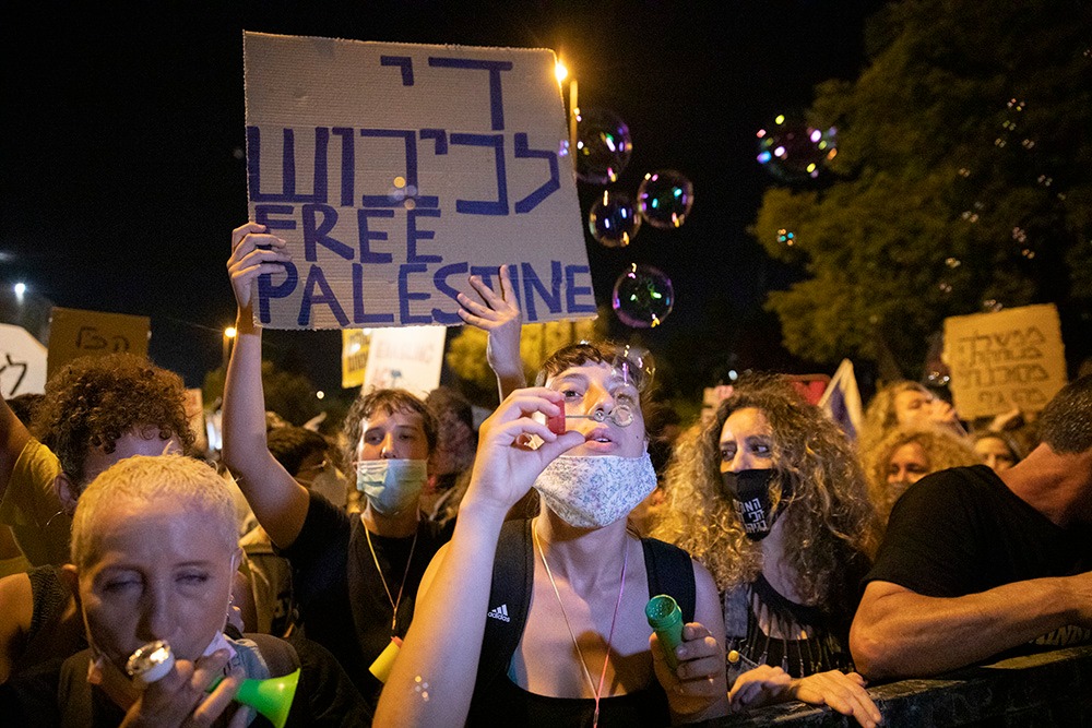 Israeli protesters carry signs saying 'End the occupation - Free Palestine' during anti-Netanyahu demonstrations in Jerusalem, July 2020. (Oren Ziv/Activestills)