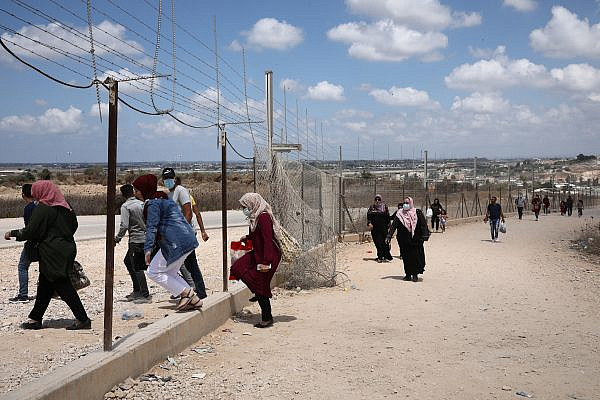 Palestinians walking through a hole in the Israeli separation barrier next to the West Bank village of Far’oun near Tulkarem. (Activestills)