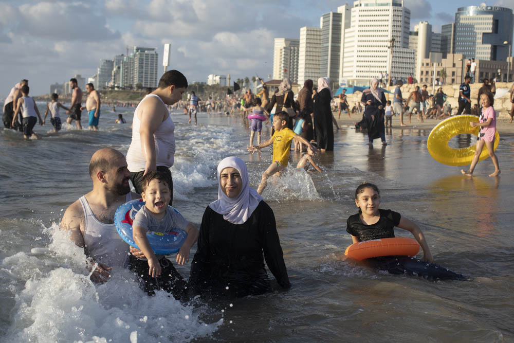 A Palestinian family enjoys the sea on the Jaffa beach. (Oren Ziv/Activestills)