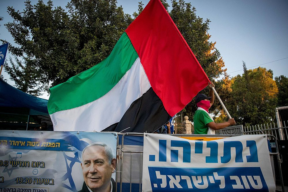 A man waves a United Arab Emirates flag outside the Israeli Prime Minister's official residence in Jerusalem, August 19, 2020. (Yonatan Sindel/Flash90)