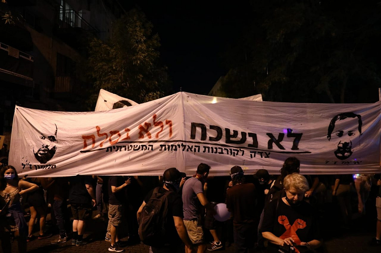 Protesters carry a sign demanding justice for the police killings of Palestinian Iyad al-Hallaq and Ethiopian Israeli Solomon Tekah during an anti-Netanyahu demonstration in Jerusalem, August 1, 2020. (Oren Ziv/Activestills)